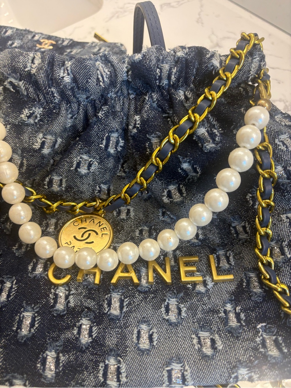 Denim Drawstring Bucket Bag with Pearl & Gold Chain Detail
